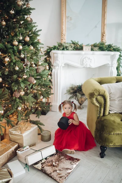 Preciosa niña en vestido rojo con regalo de Navidad . — Foto de Stock