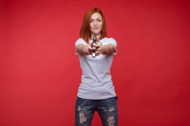 Stüdyoda poz veren beyaz tişörtlü mutlu bayan.