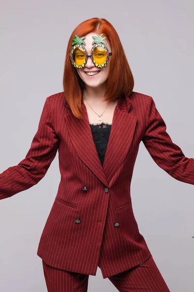 Porträtt av glad ung affärskvinna i kostym bär roliga glasögon poserar isolerad — Stockfoto