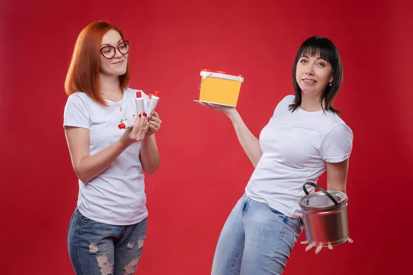 Women with building materials on red background.