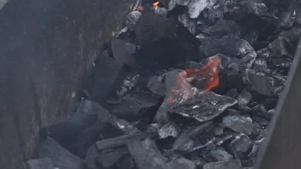 Primo piano bruciato di carboni ardenti nella griglia barbecue slow motion vista dall'alto 4k filmati — Video Stock