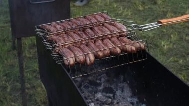 Close-up cooking fresh meat at barbecue on coal flame using grid outdoor 4k footage