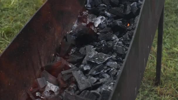Сжигание угля в гриле на открытом воздухе. Чугунный гриль с черным углем и огнем . — стоковое видео