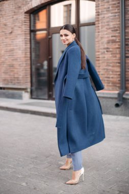 Beautiful stylish lady in blue coat and heels.
