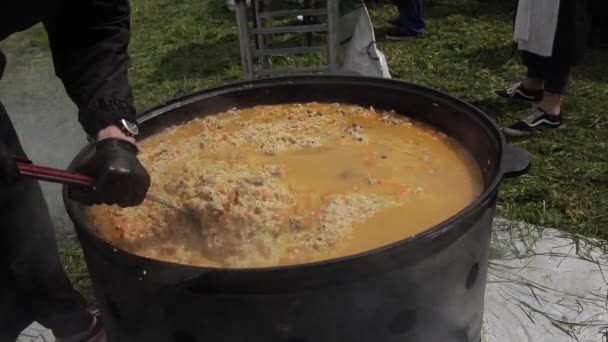 Cocinero está mezclando pilaf y cuchara de cocina — Vídeo de stock