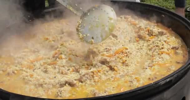 Cocinero está mezclando pilaf y cuchara de cocina — Vídeo de stock