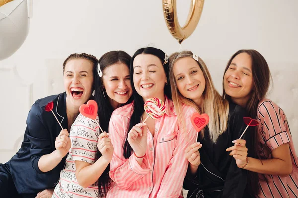 Portrait de jeune amie heureuse posant avec des bonbons sucrés colorés regardant la caméra — Photo