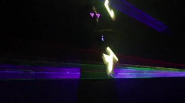 Renkli lazer ışıkları koyu arkaplanda görünüyor