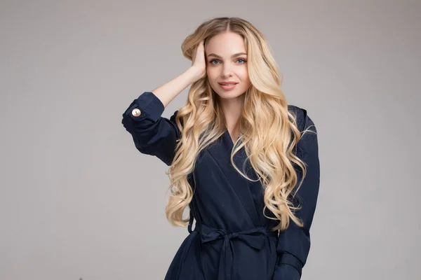 Hübsche junge Dame im eleganten Trenchcoat spaziert im Atelier — Stockfoto