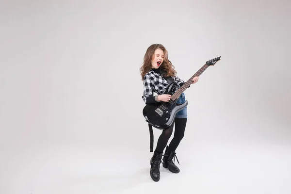 Happy beautiful artistic small girl playing guitar in studio — Stock Photo, Image