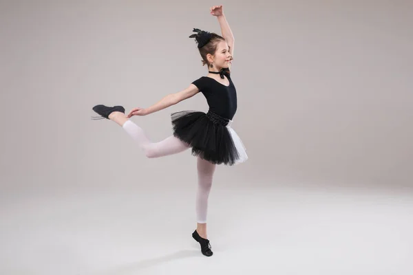 Kleine Ballerina tanzt in schwarz-weißer Kleidung und lächelt mit positiver Emotion — Stockfoto