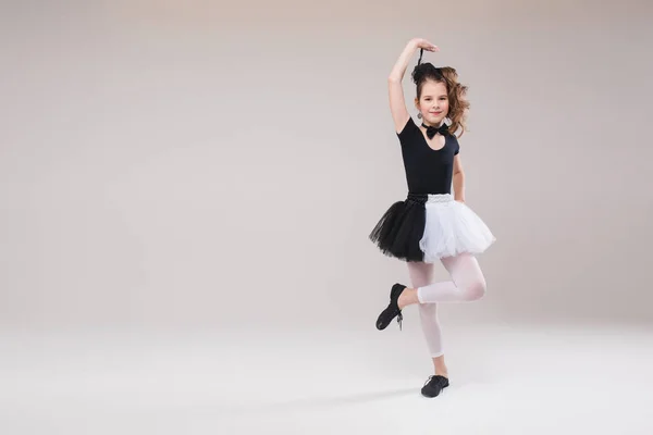 Kleine Ballerina tanzt in schwarz-weißer Kleidung und lächelt mit positiver Emotion — Stockfoto