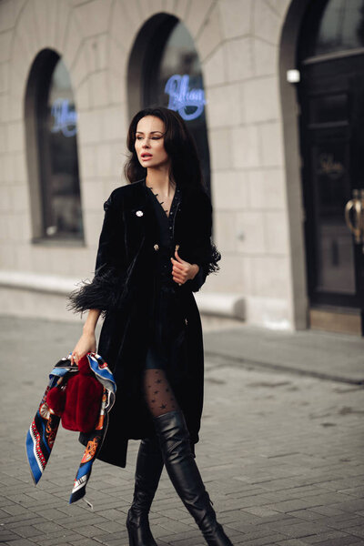 Stylish brunette in handkerchief walking in the street.