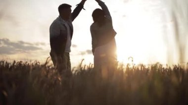 Romantik çift gün batımında dans ediyor..