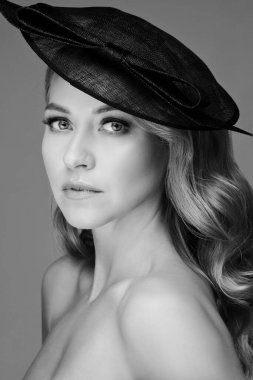Siyah şapkalı, doğal makyajlı, büyüleyici bir kadın..
