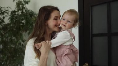 Çocuk evde annesiyle gülüyor ve gülümsüyor.