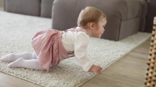 Smějící se roztomilé malé dítě dívka hraje s míčem doma koberec baví — Stock video