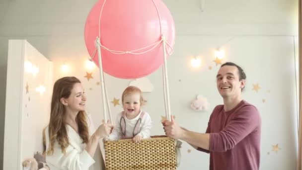 Papá y mamá llevando globo de aire con su hija . — Vídeo de stock