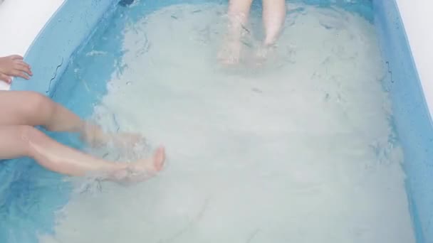 Sluiten van baby meisje benen in het water — Stockvideo