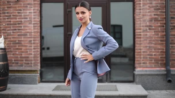 Beautiful brunette posing in stylish blue suit in the street. — Stok video