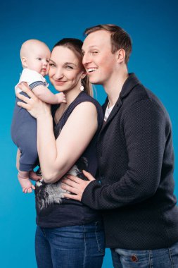 Young family spend time together and smiles, picture isolated on blue background