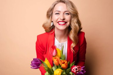 Happy beautiful woman posing with flowers and laughing