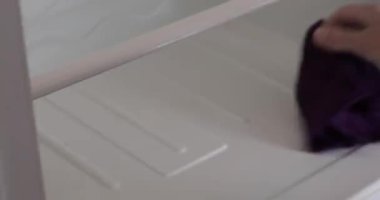 Female hand is cleaning inside the refrigerator