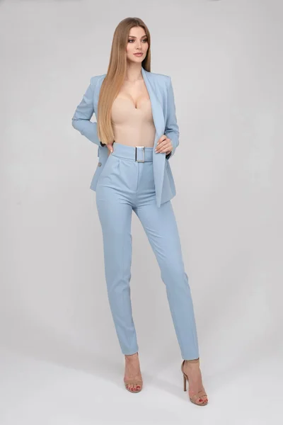 Adorable young fashion female model posing in trendy blue pantsuit full length isolated — Zdjęcie stockowe