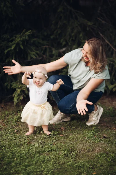 Picture of beautiful little baby goes for a walk in the park with her mother and she is interested — 图库照片