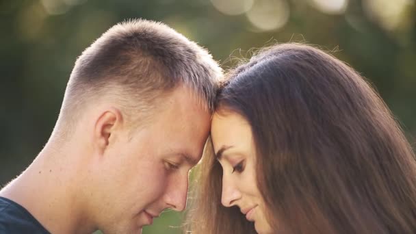 Portret van verliefd echtpaar ontspannen op vakantie, knuffelen elkaar en glimlacht geïsoleerd op wazige achtergrond — Stockvideo