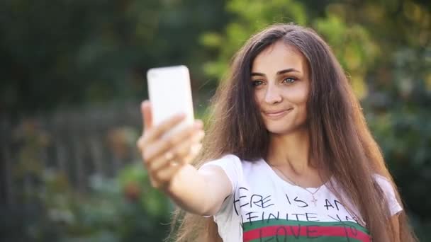 Vrolijke vrouw neemt selfie met smartphone. — Stockvideo