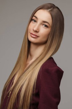 Smiling pretty lady with with long wavy hair looking at camera