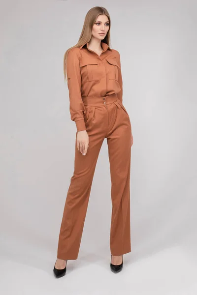 Attractive young blonde model with perfect slim body posing in trendy orange pantsuit full length — 스톡 사진