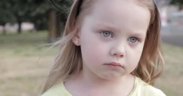 Ein nachdenkliches kleines Mädchen, das sich die Nase zupft. — Stockvideo