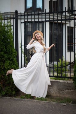 Gülümseyen genç, modaya uygun bir kız şehirde poz veriyor.