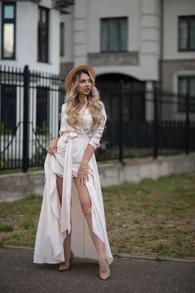 Ritratto di bella donna con lunghi capelli biondi in lungo abito bianco cammina fuori — Foto Stock