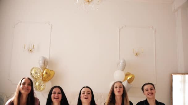 Fem glada damer i pyjamas hoppar upp och har mycket roligt tillsammans — Stockvideo