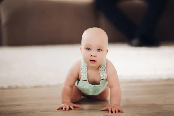 Cute little toddler baby wearing stylish overalls sitting on floor looking at camera — Stock Photo, Image
