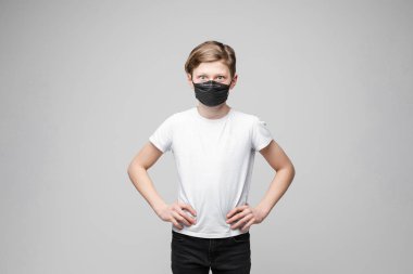 Beyaz stüdyo arka planında izole edilmiş, koruyucu maske takan sıradan bir genç.