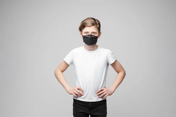 Adolescente casual chico posando en protección máscara medio disparo aislado en blanco estudio fondo — Foto de Stock