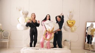 Mutlu güzel kız arkadaşlar yatakta eğleniyor.