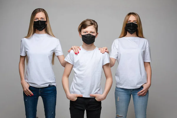 Twee vrouw en tiener jongen dragen medisch beschermend masker poseren samen geïsoleerd — Stockfoto