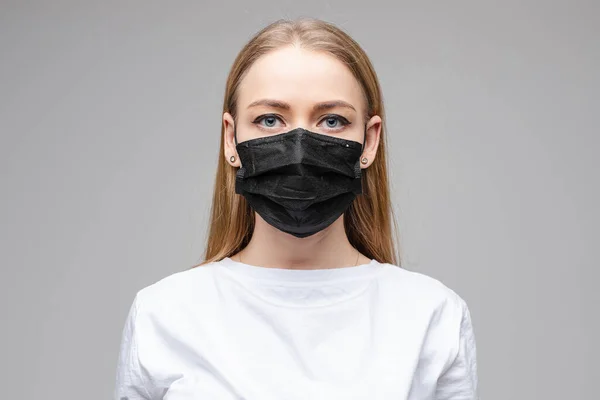 Genç kadın tıbbi maske takıyor.
