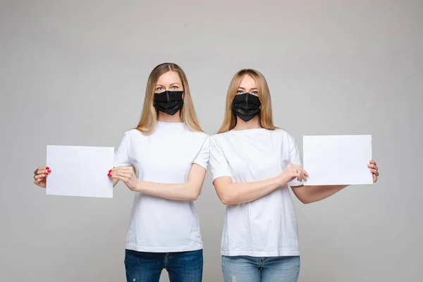 Jonge dames in chirurgische maskers poseren in de studio — Stockfoto