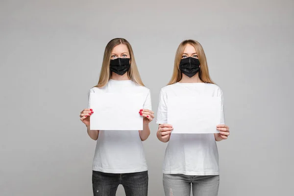 Twee vrouwen met maskers en spandoeken. Stoppen met virussen. — Stockfoto