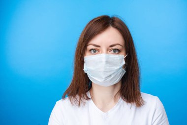 Aseptik maske takan esmer kadın. açık mavi arkaplan