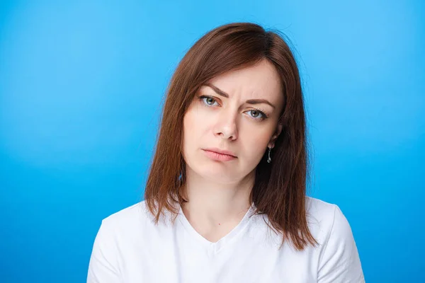 Mooie blanke vrouw die ontevreden is. lichtblauwe achtergrond — Stockfoto