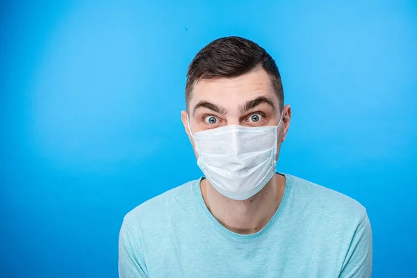 Наляканий чоловік в медичній масці дивиться в камеру — стокове фото