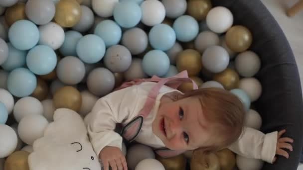 Schattig baby meisje spelen in bal zwembad. — Stockvideo