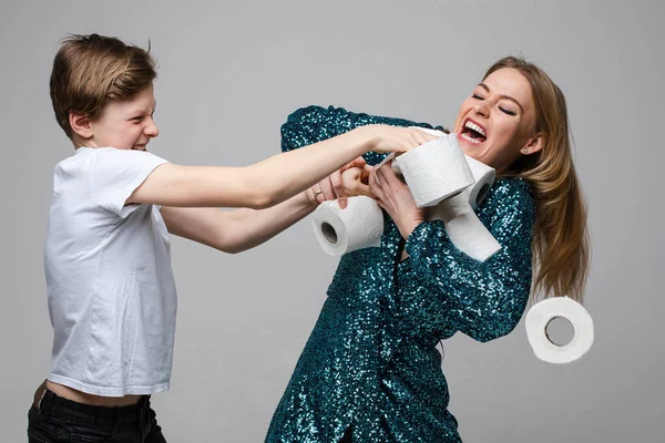 Jeune belle fille se bat pour beaucoup de papier toilette avec un jeune garçon, portrait isolé sur fond blanc — Photo